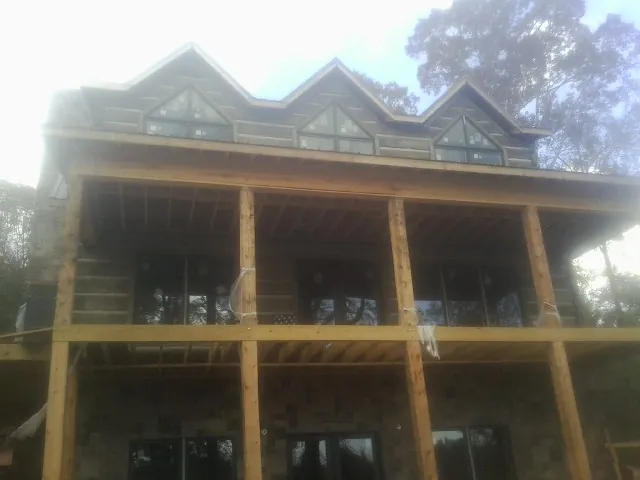 Dormers and porch framing on a large log home under construction — Roof Coating work by our crew in Peachland