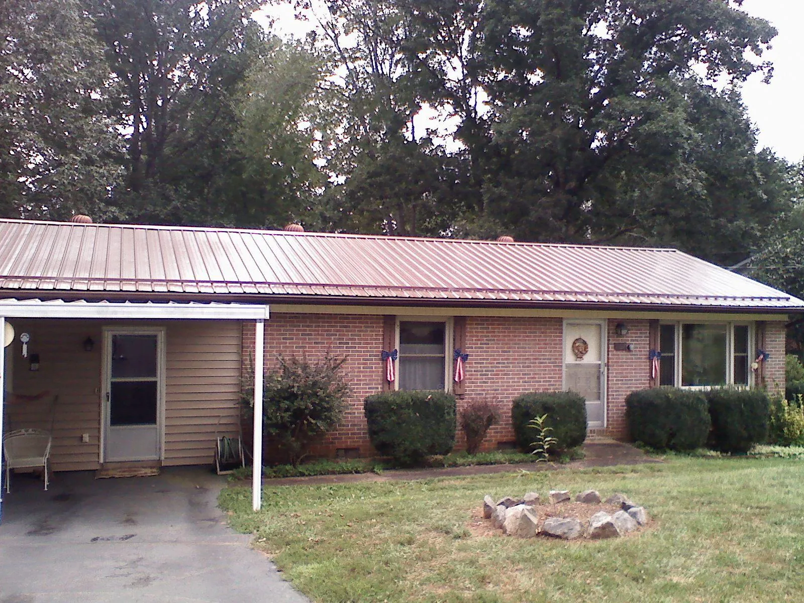 Bronze metal roof and carport on a brick ranch home — Roof Repair work by our crew in Peachland