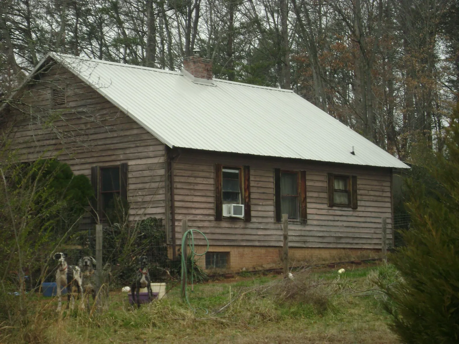 White metal roof on an old wood sided farmhouse, from a Metal Roof Installation job in Peachland